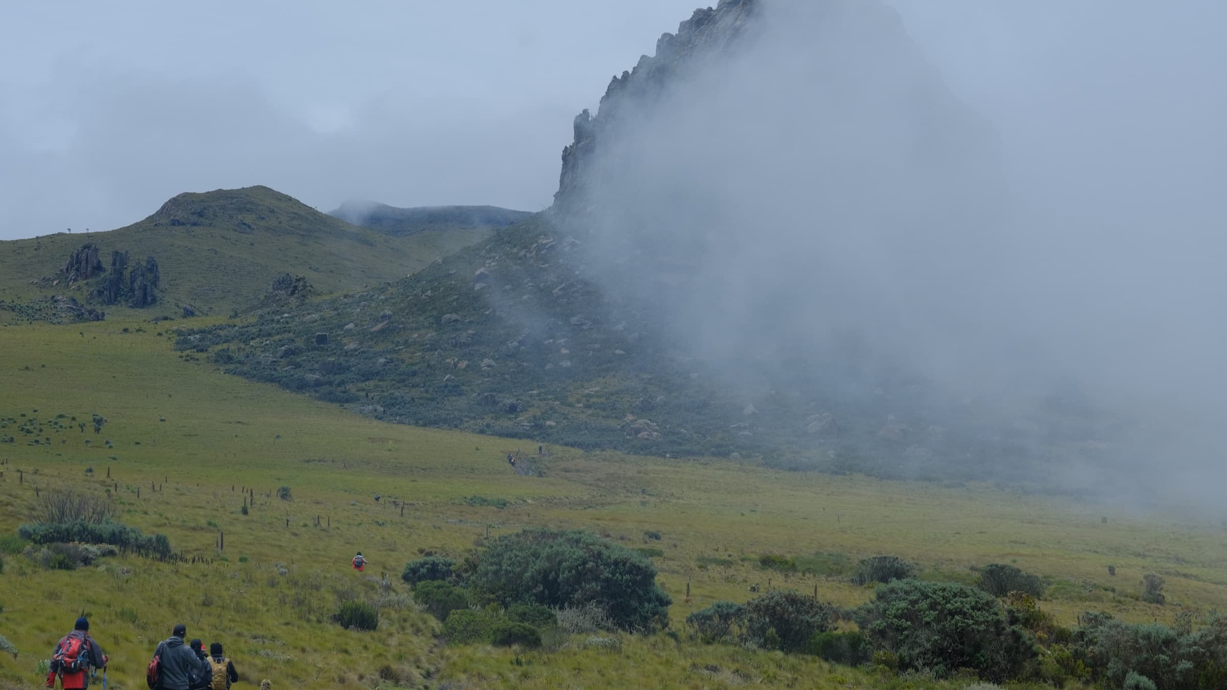 Misty crags of Oldonyo Lesatima with hikers in the foreground