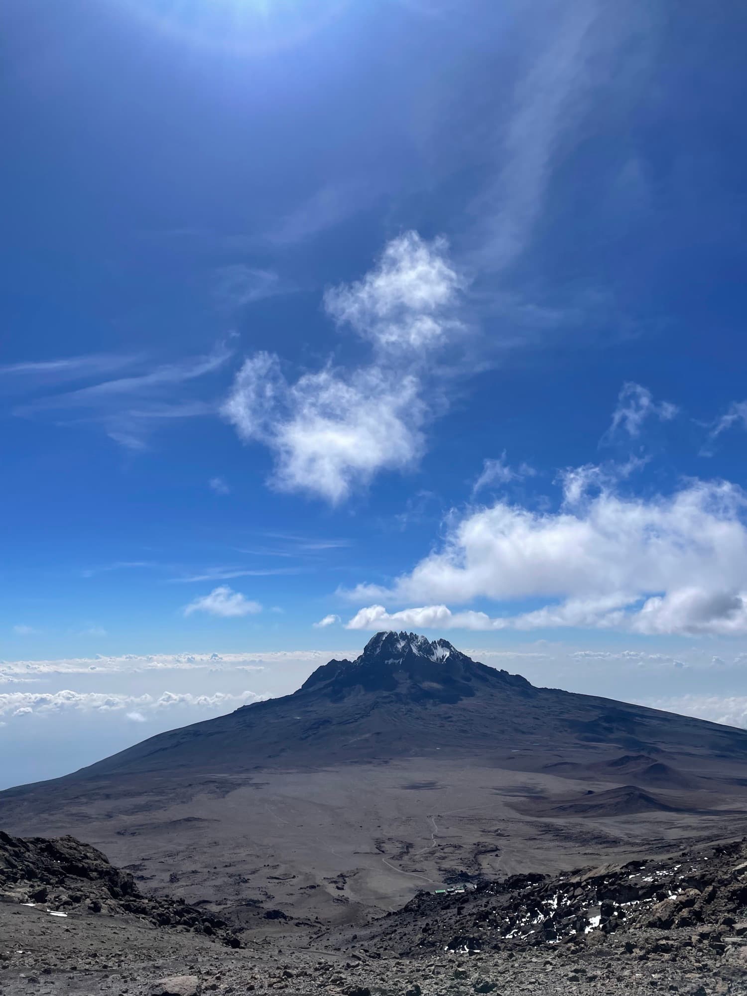 Mawenzi's dark massif under a towering white cloud, seen from the Saddle plain