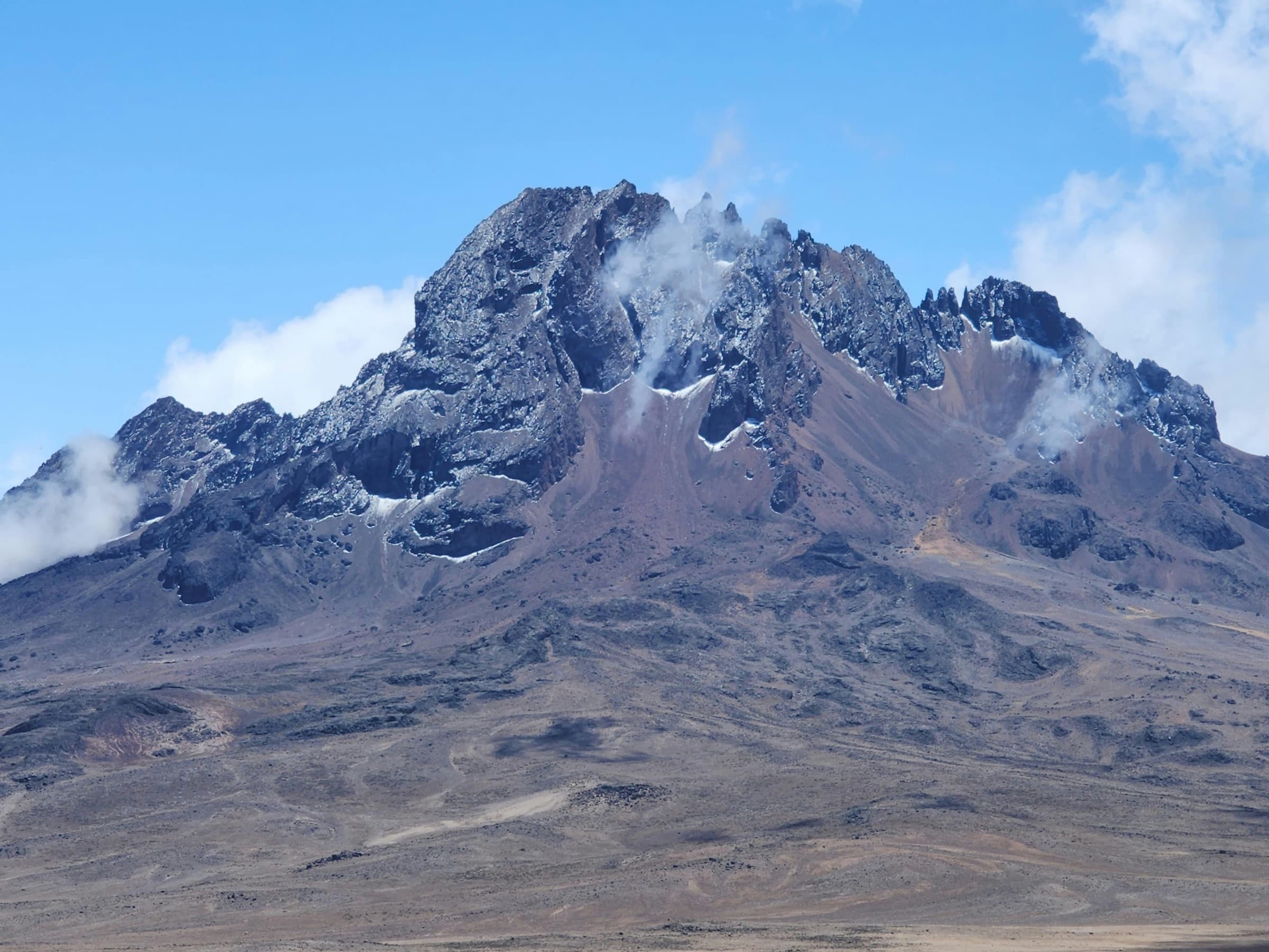 Rocky peak rising above scree and boulder fields on Mount Kenya
