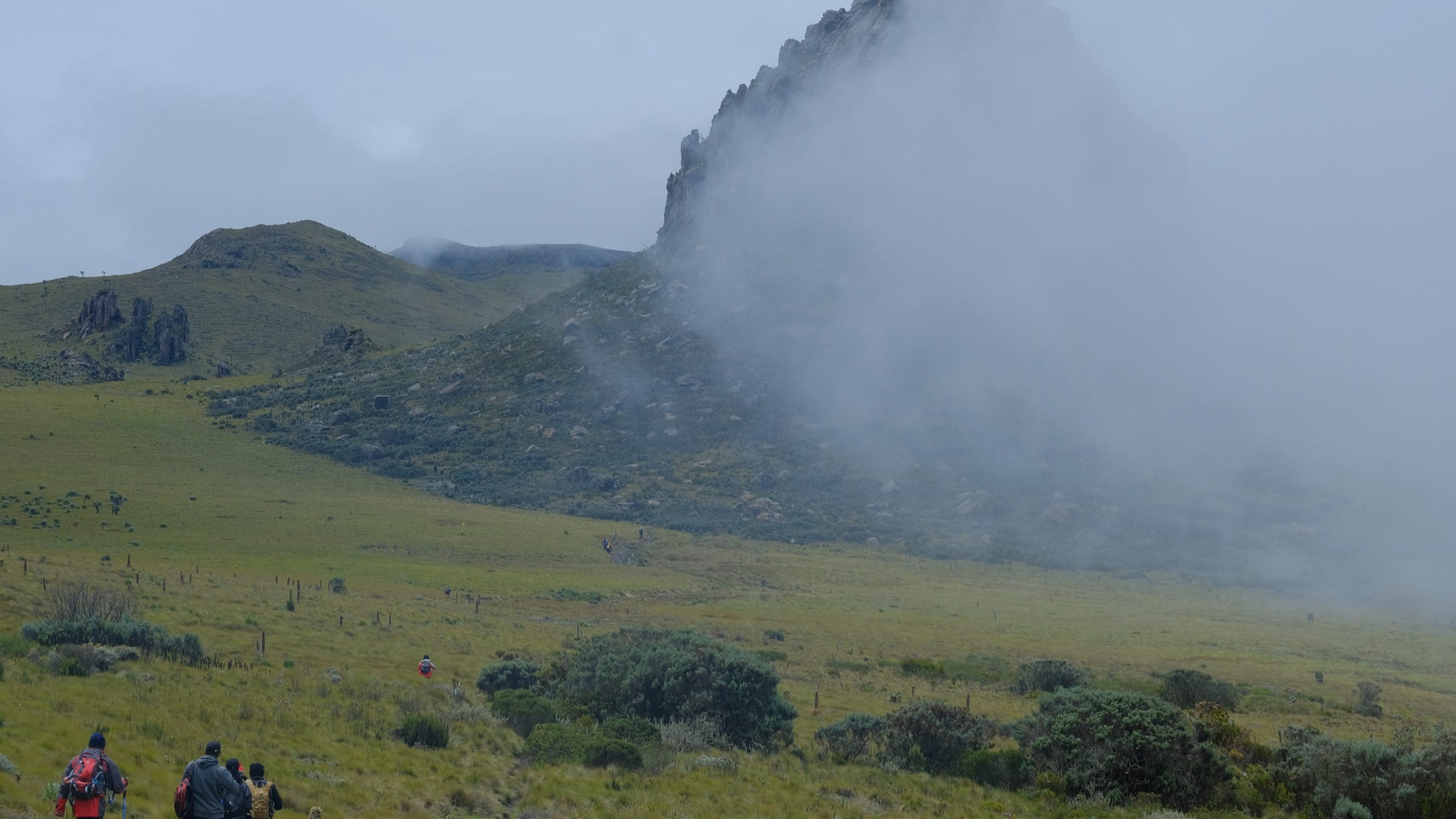 Misty crags of Oldonyo Lesatima with hikers in the foreground